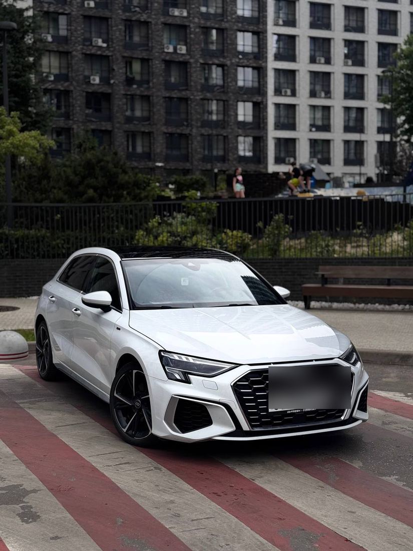 Audi A3 Sportback во дворе на фоне жилого дома — общий вид экстерьера