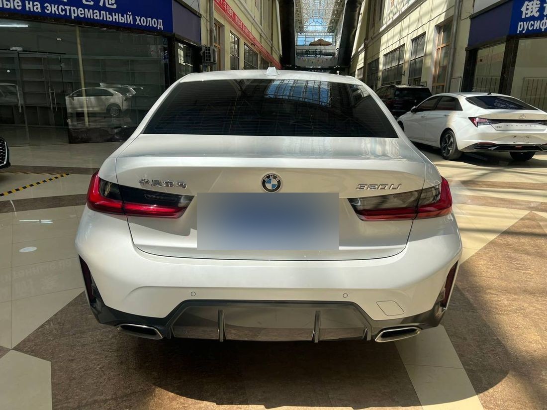 Белая BMW 320Li — вид сзади-сбоку в выставочном зале