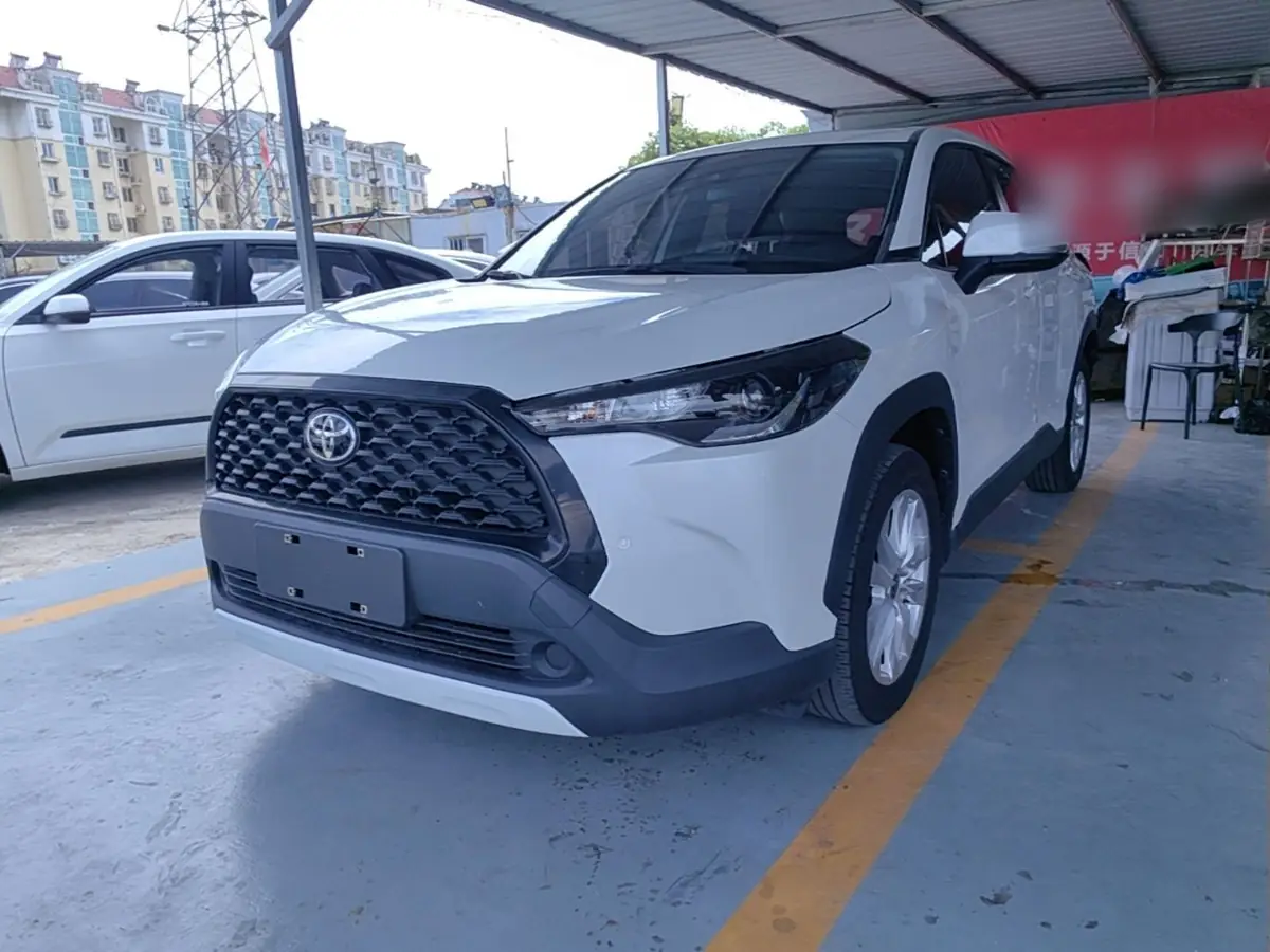 Белая Toyota Corolla Cross из Китая спереди три четверти на площадке